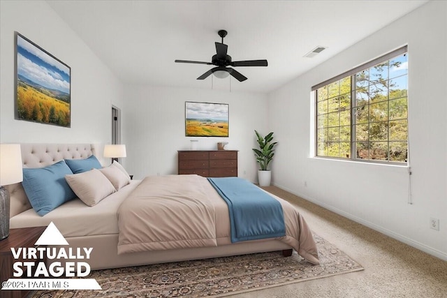 carpeted bedroom with visible vents, baseboards, and a ceiling fan