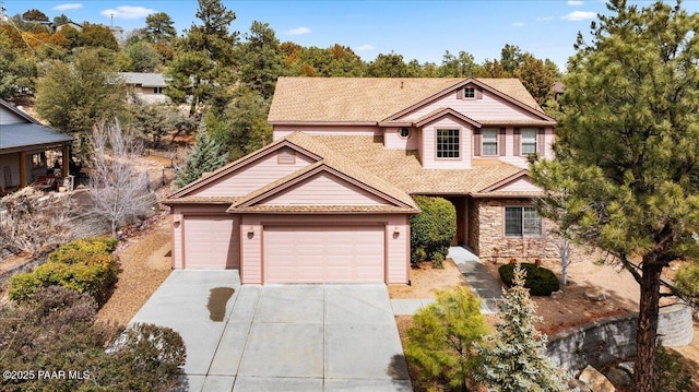 view of front of property with stone siding, concrete driveway, and a garage