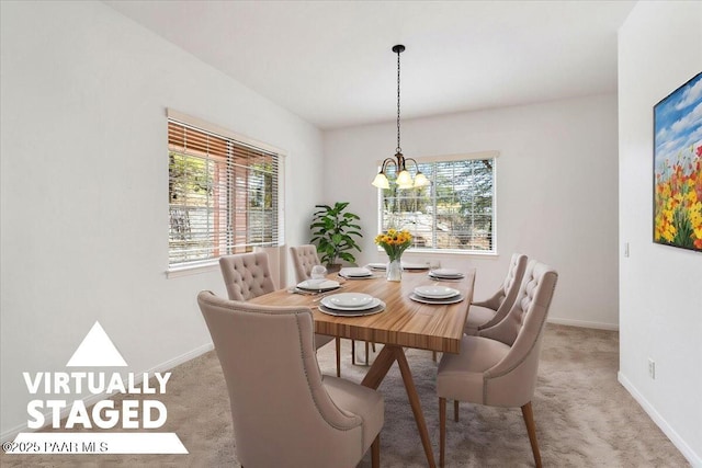 carpeted dining space featuring an inviting chandelier and baseboards