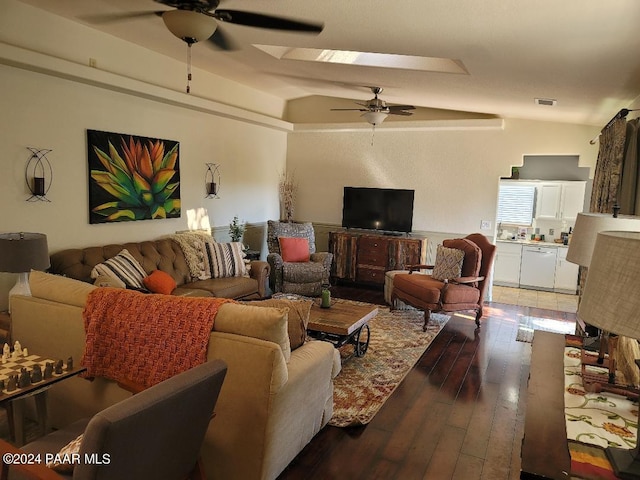 living room featuring dark hardwood / wood-style floors, ceiling fan, and lofted ceiling with skylight