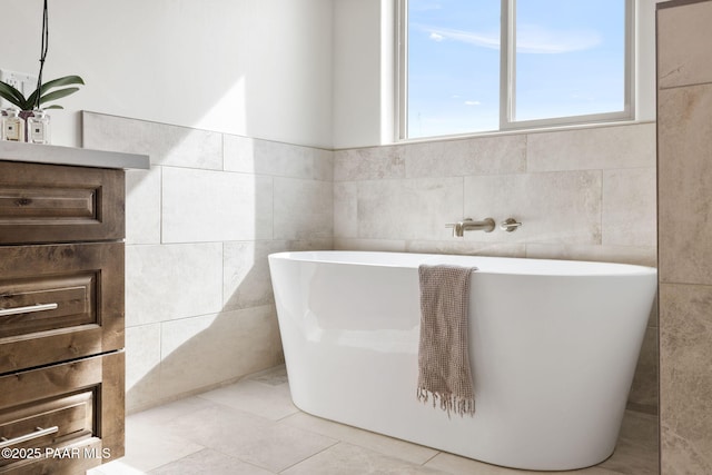 bathroom with a freestanding bath and tile walls