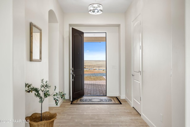 entryway with baseboards and wood finished floors