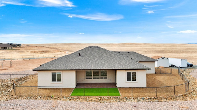 back of house with a fenced backyard, stucco siding, and a shingled roof