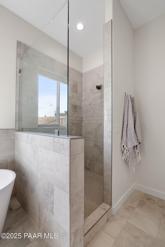 bathroom featuring a freestanding tub, baseboards, and walk in shower