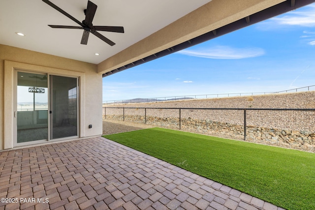 view of patio with fence and a ceiling fan