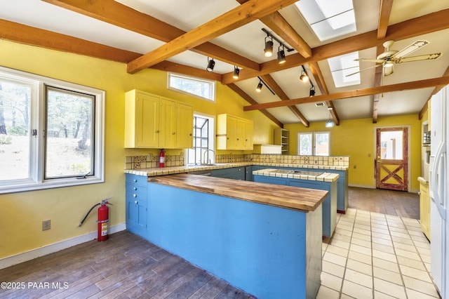 769 Cherokee Rd, Prescott, AZ 86303 - kitchen featuring a peninsula, a skylight, butcher block countertops, light wood finished floors, and ceiling fan