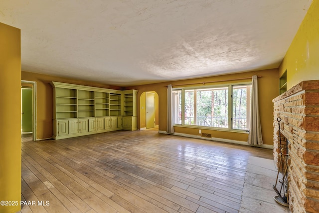 769 Cherokee Rd, Prescott, AZ 86303 - unfurnished living room featuring arched walkways and light wood-style floors