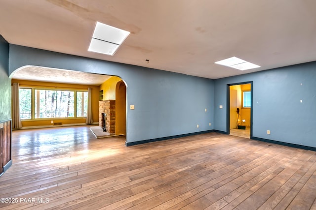 769 Cherokee Rd, Prescott, AZ 86303 - spare room with a skylight, arched walkways, and hardwood / wood-style floors