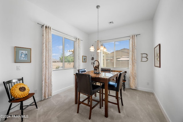 carpeted dining room with a notable chandelier and plenty of natural light