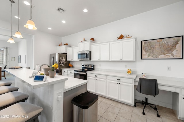 kitchen with a breakfast bar, stainless steel appliances, decorative light fixtures, a center island with sink, and white cabinets