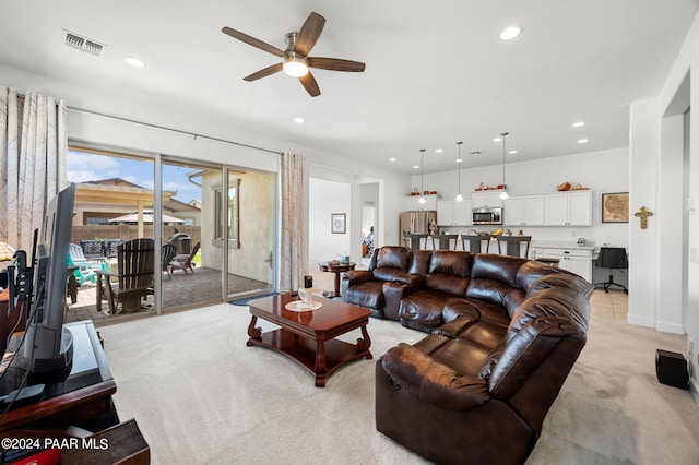 carpeted living room with ceiling fan