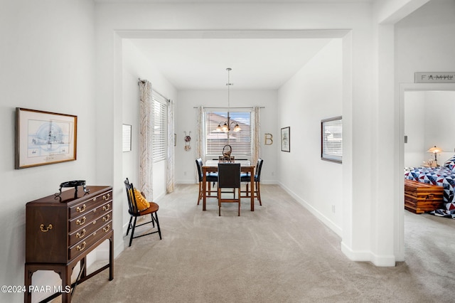 dining area featuring light carpet and an inviting chandelier