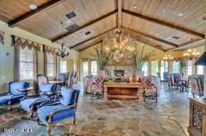 living room featuring beamed ceiling, plenty of natural light, wooden ceiling, and an inviting chandelier