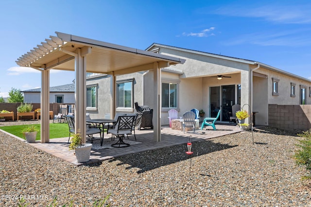 rear view of house featuring ceiling fan and a patio area