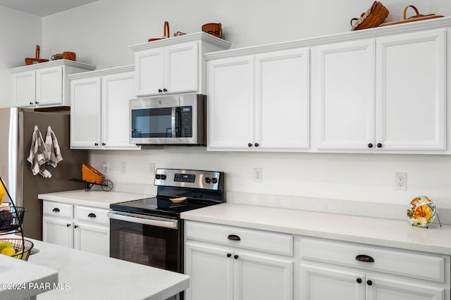 kitchen with white cabinets and appliances with stainless steel finishes