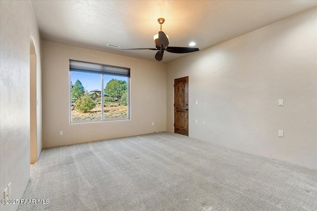 empty room featuring ceiling fan and light colored carpet