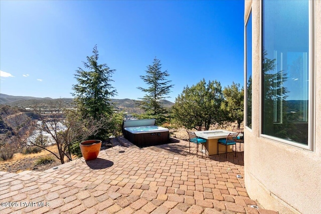 view of patio / terrace featuring a mountain view and a hot tub