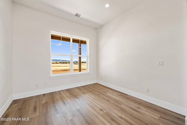 unfurnished room featuring baseboards, visible vents, wood finished floors, and recessed lighting