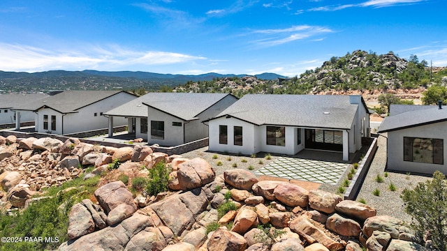 rear view of house with a mountain view and a patio