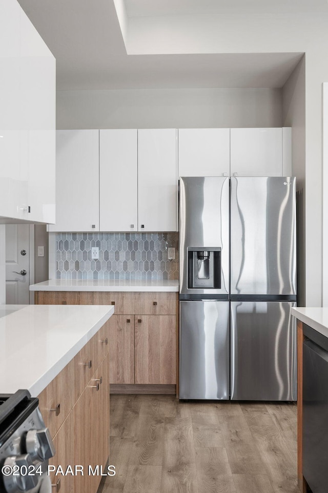 kitchen featuring white cabinets, light wood-type flooring, and appliances with stainless steel finishes