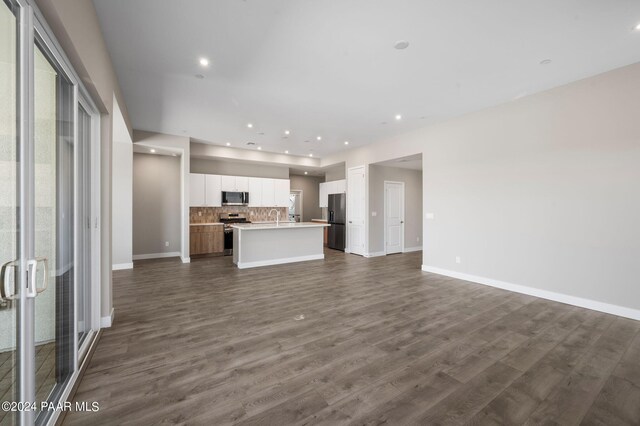 unfurnished living room featuring dark hardwood / wood-style floors and sink