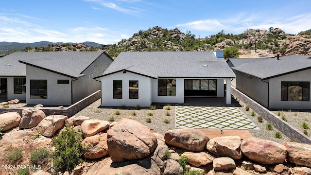 rear view of house with a mountain view and a patio