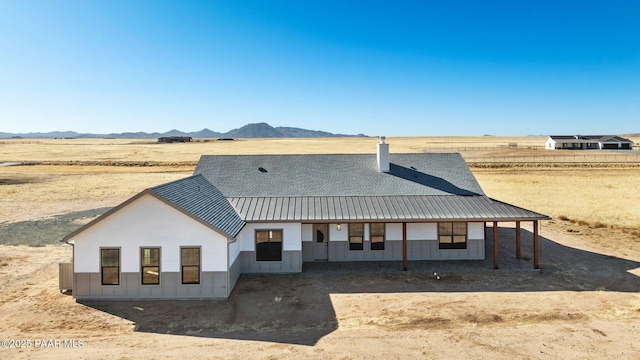 view of front of property with a rural view and a mountain view