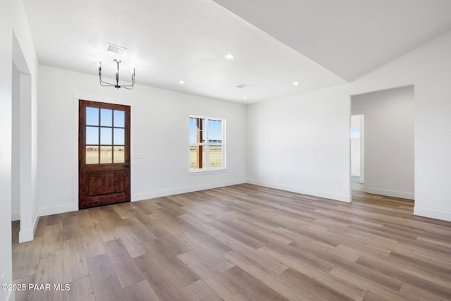 entrance foyer with an inviting chandelier and light hardwood / wood-style floors