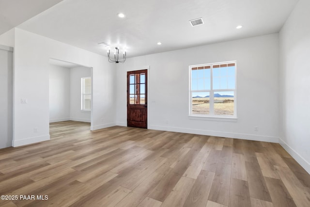 foyer entrance featuring light hardwood / wood-style floors and a chandelier