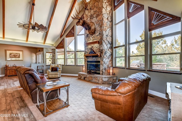 living room featuring ceiling fan, plenty of natural light, a fireplace, and high vaulted ceiling