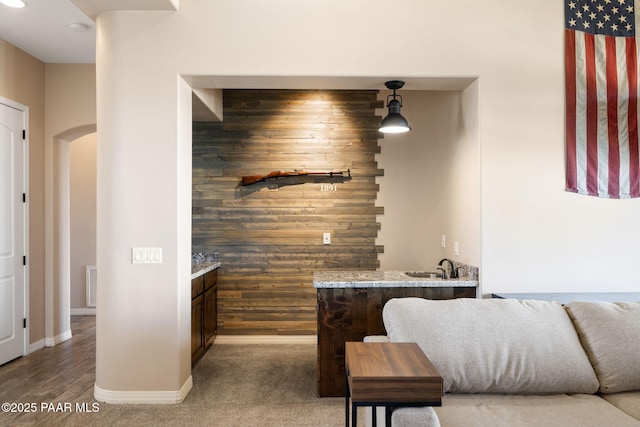 12300 W Slate Rd, Prescott, AZ 86305 - carpeted bedroom with visible vents, arched walkways, wood walls, indoor wet bar, and baseboards