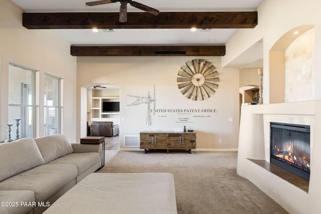 12300 W Slate Rd, Prescott, AZ 86305 - living area featuring visible vents, a ceiling fan, arched walkways, carpet floors, and a tile fireplace