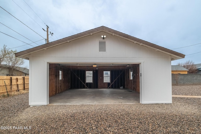 detached garage featuring fence