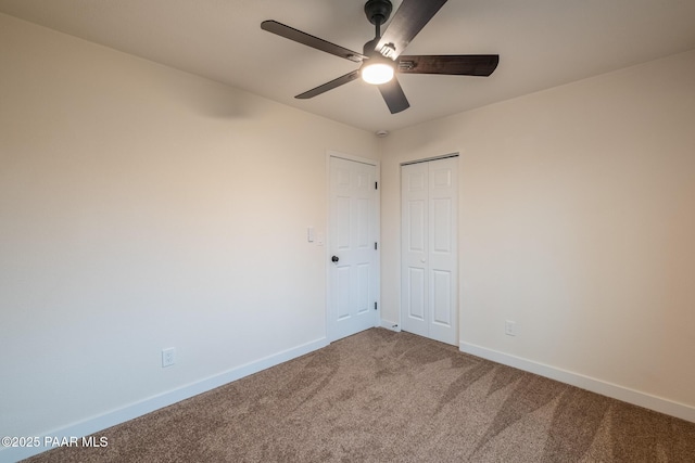 spare room featuring carpet, baseboards, and ceiling fan