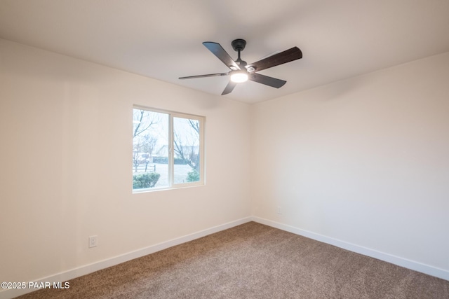 spare room featuring carpet flooring, a ceiling fan, and baseboards