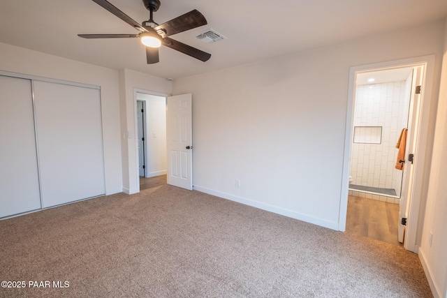 unfurnished bedroom featuring visible vents, ensuite bath, a closet, carpet floors, and baseboards