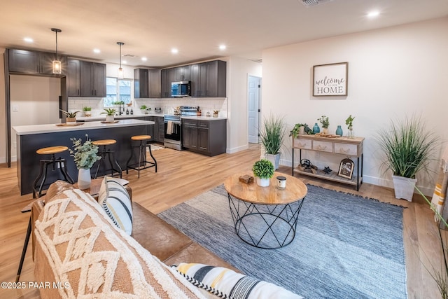 living room featuring visible vents, recessed lighting, baseboards, and light wood-style floors