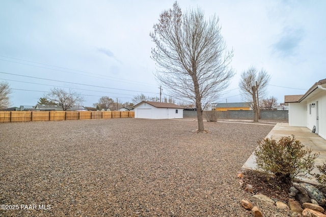 view of yard featuring an outdoor structure and fence