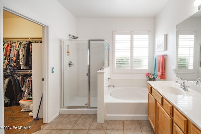 bathroom with tile patterned floors, vanity, and shower with separate bathtub