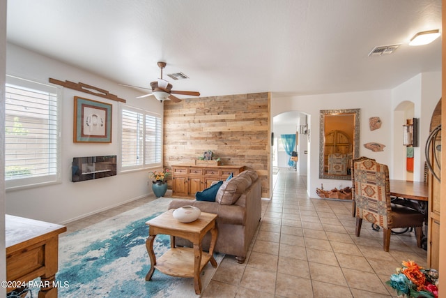 tiled living room with wood walls and ceiling fan