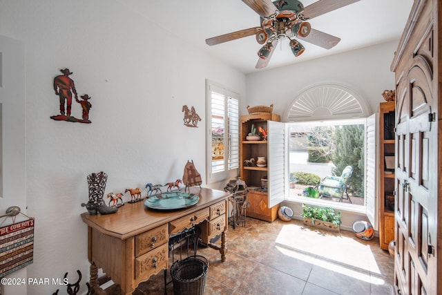 tiled home office featuring ceiling fan