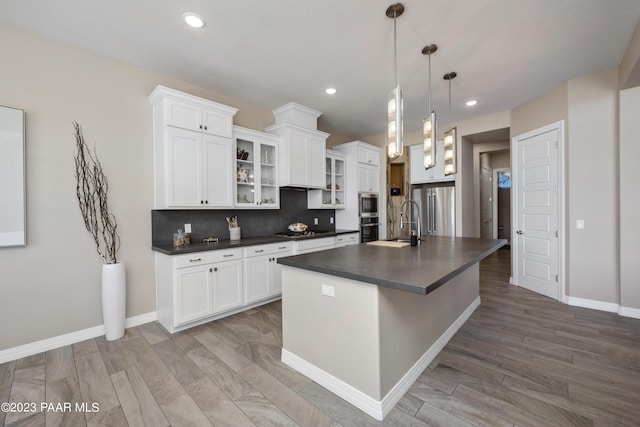 3771 Blazing Ore Trl, Prescott, AZ 86301 - kitchen featuring high end fridge, wood-type flooring, a center island with sink, white cabinetry, and hanging light fixtures