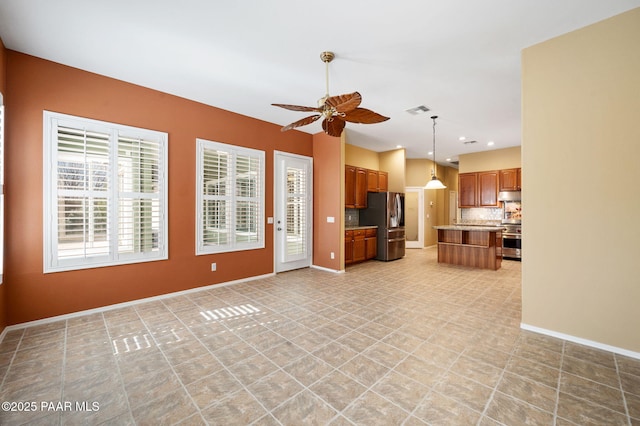 7708 N Siesta Sunset Ln, Prescott Valley, AZ 86315 - kitchen featuring appliances with stainless steel finishes, a ceiling fan, brown cabinetry, under cabinet range hood, and open floor plan