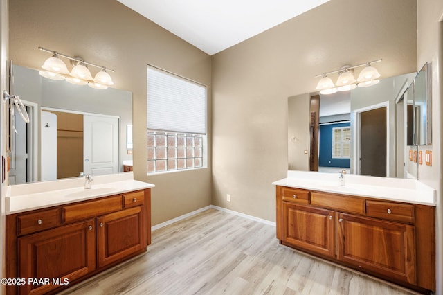 7708 N Siesta Sunset Ln, Prescott Valley, AZ 86315 - bathroom featuring two vanities, wood finished floors, and baseboards