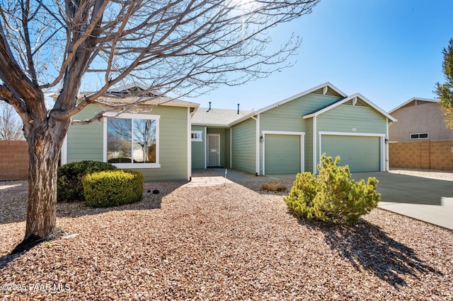 single story home featuring a garage, driveway, and fence