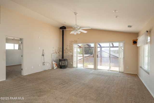 1269 N Oxbow Dr, Dewey-Humboldt, AZ 86327 - unfurnished living room featuring vaulted ceiling, ceiling fan, carpet flooring, and a wood stove