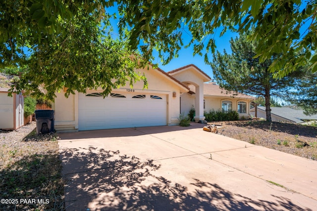 1269 N Oxbow Dr, Dewey-Humboldt, AZ 86327 - view of front of home featuring an attached garage, stucco siding, concrete driveway, and a tiled roof