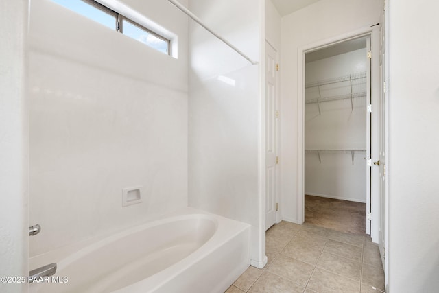 bathroom featuring baseboards, a spacious closet, and tile patterned floors