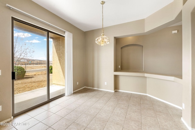 empty room with tile patterned flooring, a chandelier, and baseboards