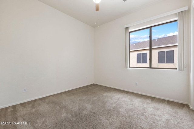 carpeted empty room featuring ceiling fan and baseboards